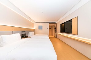 A hotel room with a large bed, bedside tables, a flat-screen TV, and a mirror. - Ji Hotel (hangzhou West Lake Hubin Pedestrian Stre (Hangzhou)