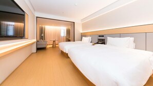 A hotel room with two beds, a TV, a desk, and a view of the city. - Ji Hotel (hangzhou West Lake Hubin Pedestrian Stre (Hangzhou)
