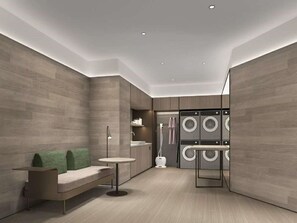 A modern laundry room with a built-in washer and dryer, a small table, and a bench. - Ji Hotel (hangzhou West Lake Hubin Pedestrian Stre (Hangzhou)