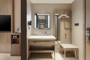 A modern bathroom with a large mirror, a sink, a towel rack, and a bench. - Hanting Hotel (xianyang International Airport Hote (Xianyang)