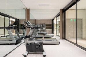 A modern gym with stationary bikes, treadmills, and a rowing machine. - Hanting Hotel (xianyang International Airport Hote (Xianyang)