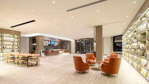 A modern library with a reception desk, seating area, and bookshelves. - Hanting Hotel (xianyang International Airport Hote (Xianyang)