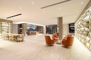 A modern library with a reception desk, seating area, and bookshelves. - Hanting Hotel (xianyang International Airport Hote (Xianyang)