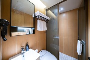 A bathroom with a mirror, a sink, a toilet, a hairdryer, and a shower. - Ji Hotel Shanghai Jiangsu Road Subway Station (Shanghai)