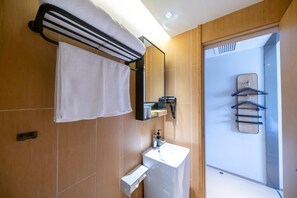 A modern bathroom with a towel rack, a sink, and a mirror. - Ji Hotel Shanghai Jiangsu Road Subway Station (Shanghai)