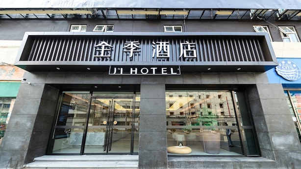 A hotel entrance with a modern facade, large glass doors, and a sign indicating it's a hotel. - Ji Hotel Shanghai Jiangsu Road Subway Station (Shanghai)