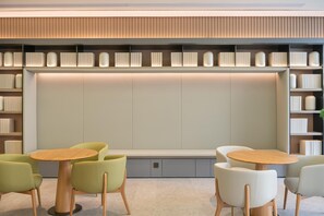 Un interior moderno con una zona de estar, estanterías y una pared con recipientes iluminados.