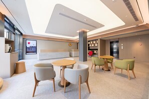 A modern lobby with a reception desk, seating area, and a large digital display. - Ji Hotel Shanghai Jiangsu Road Subway Station (Shanghai)