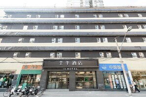 Un hotel con varios pisos, grandes ventanales y un cartel que indica que es un hotel.