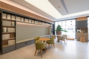 Un intérieur moderne comprenant un coin salon, des étagères et une grande fenêtre.