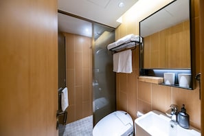 Une salle de bain moderne avec une douche à parois de verre, des toilettes blanches, un lavabo avec un robinet et un porte-serviettes.