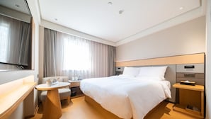 A modern hotel room with a large bed, bedside tables, a desk, and a TV. - Ji Hotel Shanghai Jiangsu Road Subway Station (Shanghai)