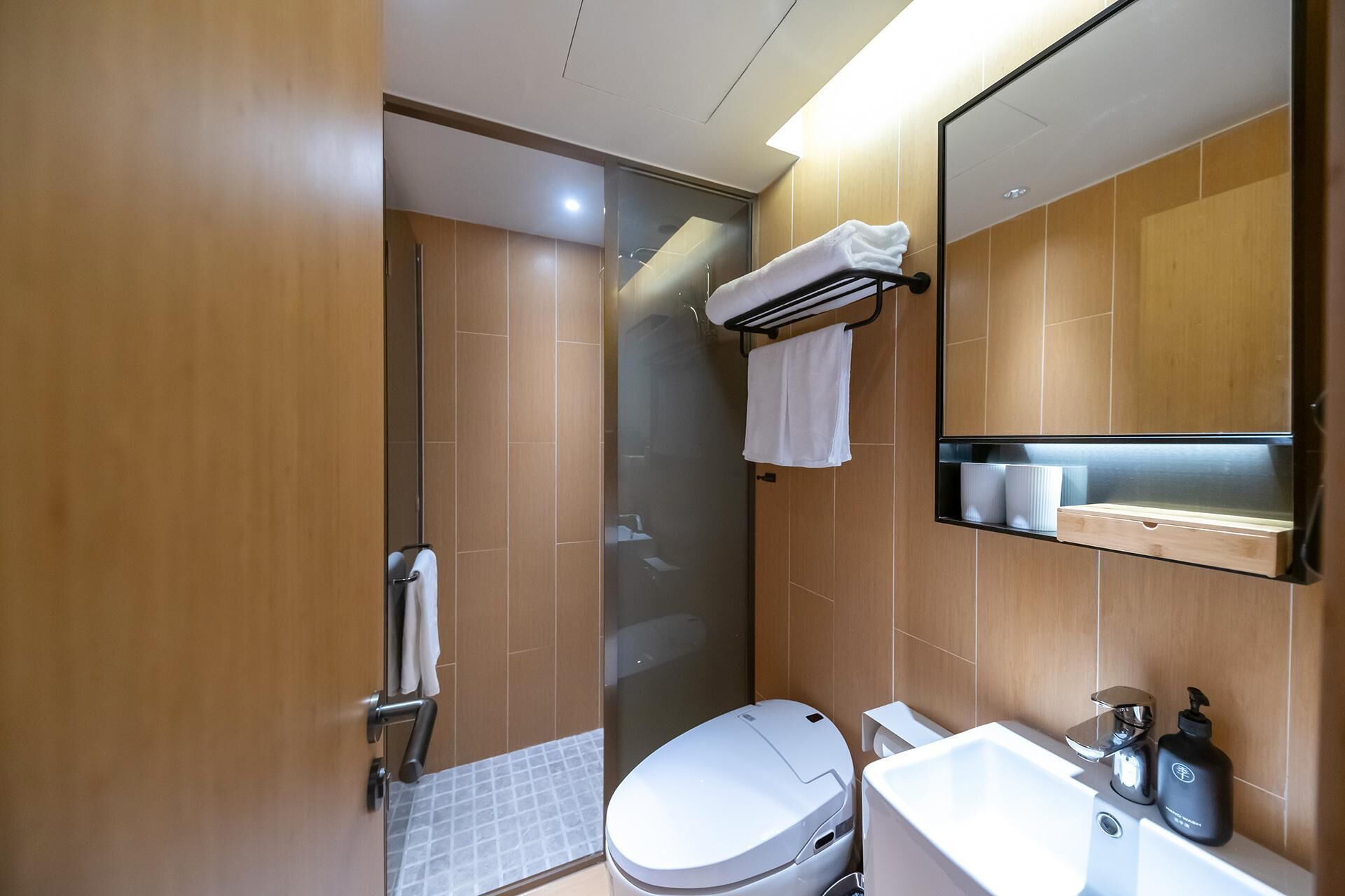 Uma casa de banho moderna com sanita, lavatório e cabine de duche em vidro.