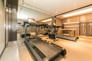 A modern gym with treadmills, elliptical machines, and a mirrored wall. - Ji Hotel (nanjing Jiangning Southeast University s (Nanjing)