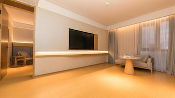 Una sala de estar moderna con un sofá, una mesa de centro, un televisor montado en la pared y un armario con puerta corredera.