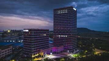 Un edificio de gran altura con varios pisos, un patio central y edificios bajos circundantes.