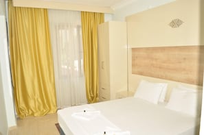 A hotel room with a bed, a wardrobe, and a window with curtains. - Kemer Suit (Kemer)