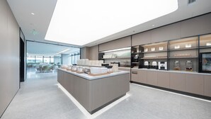 A modern kitchen with a central island, built-in appliances, and a view to a dining area. - Ji Hotel (Wuhan)