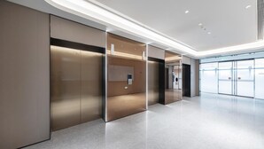 A modern interior with a glass partition, a control panel, and a clean, polished floor. - Ji Hotel (Wuhan)