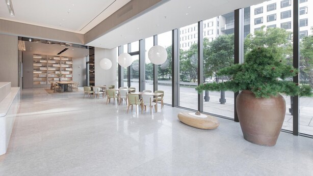A spacious lobby with a modern design, featuring a large potted plant, multiple seating areas, and a bookshelf. - Ji Hotel (Wuhan)