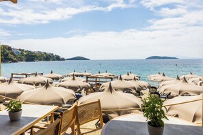 A beachside restaurant with outdoor seating, umbrellas, and a view of the sea. - Skiathos Thalassa (Skiathos)