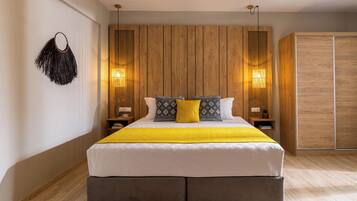 A modern bedroom with a large bed, wooden panel wall, bedside lamps, and a wardrobe.