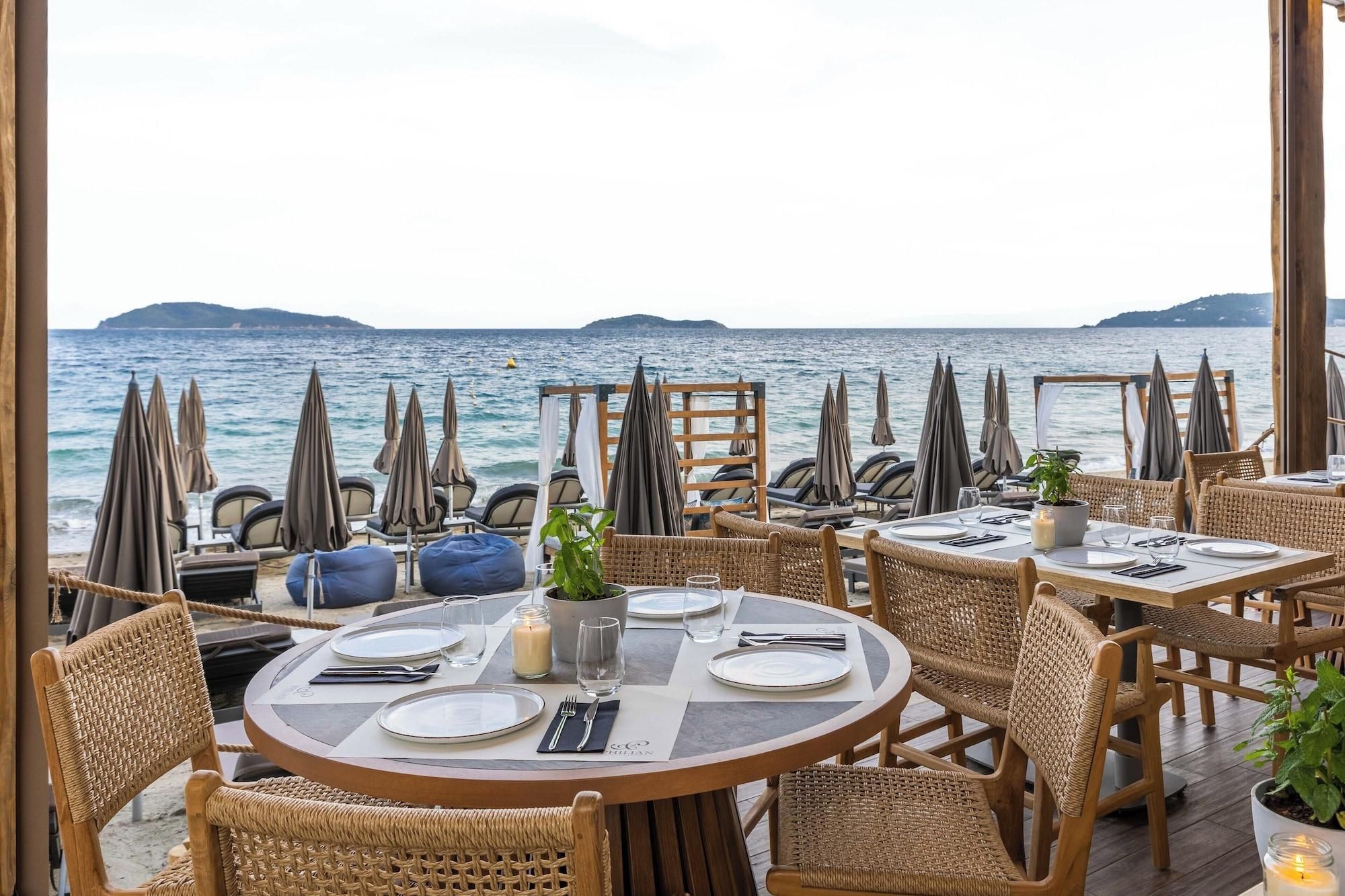 Un ristorante sul mare con mobili in vimini e vista mare.