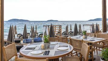Un ristorante sul mare con mobili in vimini e vista mare.