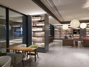 A modern bookstore interior with shelves, seating, and a digital display. - Ji Hotel (Hefei)