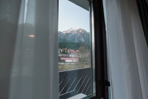 A window with a view of a mountain and buildings. - Suru Hotel (Busteni)