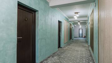 A hallway with doors, patterned carpet, and a ceiling with recessed lighting.