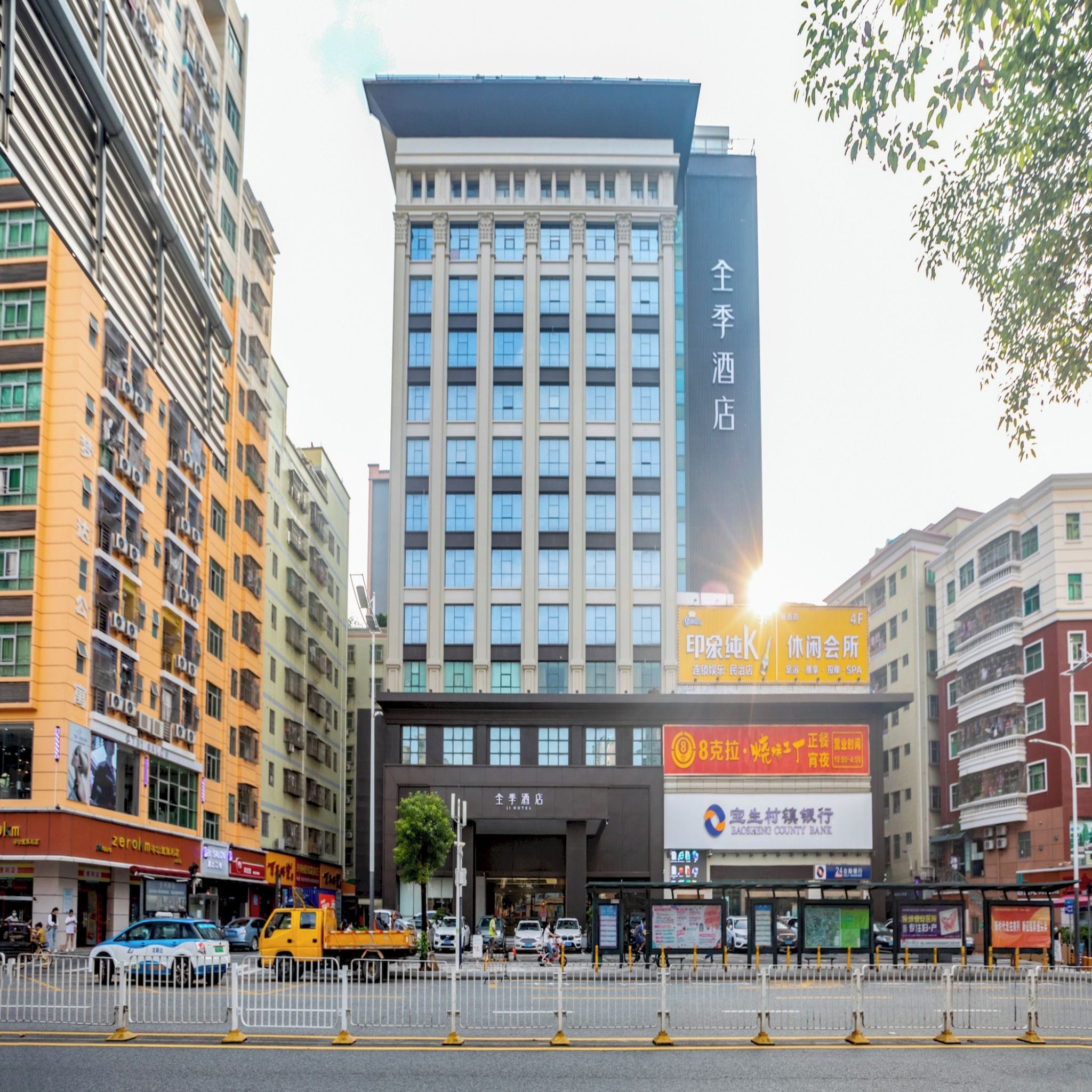 A multi-story hotel with a prominent entrance, surrounded by other buildings and a busy street.