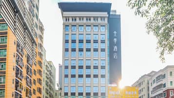 A multi-story hotel with a prominent entrance, surrounded by other buildings and a busy street.