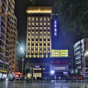 A multi-story hotel with a prominent entrance, signage for a spa, and a bank nearby. - Ji Hotel (Shenzhen)