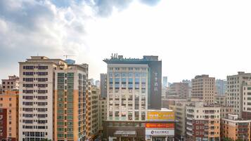 A multi-story hotel with a central entrance, surrounded by other buildings.