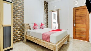 A bedroom with a wooden bed frame, a wardrobe, and a patterned wall. - OYO 90756 Melasti Hills Room & Cafe (Ungasan)