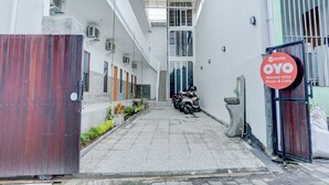 A narrow alleyway leading to a building with a sign for 'OYO Melasti Hills Room & Cafe'. - OYO 90756 Melasti Hills Room & Cafe (Ungasan)