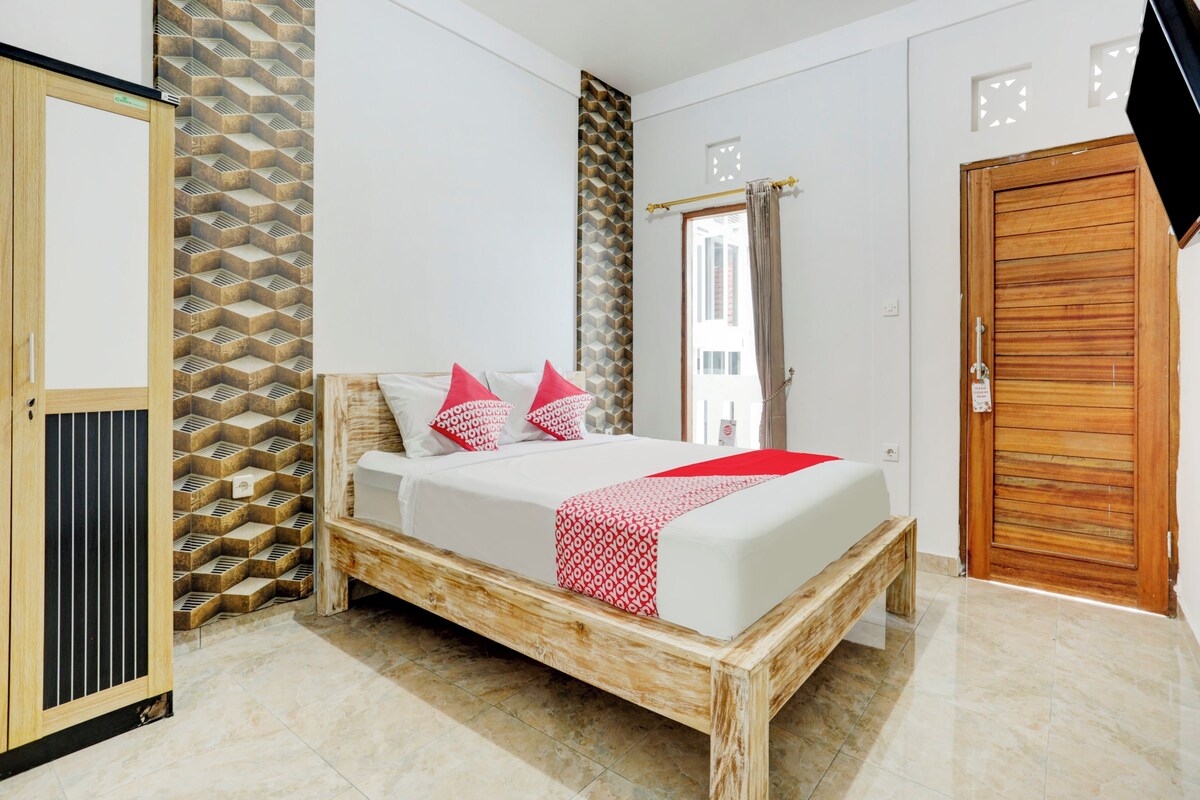 A bedroom with a wooden bed frame, a wardrobe, and a patterned wall.