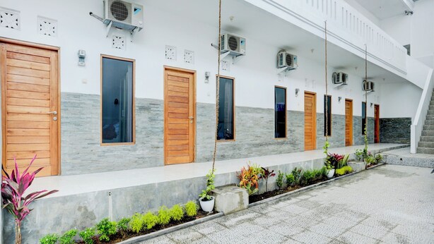 A modern building with multiple doors and air conditioning units. - OYO 90756 Melasti Hills Room & Cafe (Ungasan)