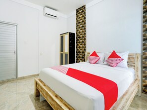 Una camera da letto con un letto, un armadio, un condizionatore d'aria e una parete decorativa.