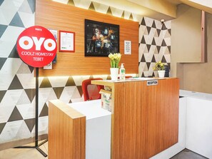 A reception desk with a 'Reception' sign, a framed certificate, and a 'Coolz Homestay Tebet' sign. - OYO 90872 Coolz Homestay Tebet (Jakarta)