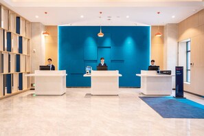 A reception area with three counters, a blue accent wall, and a modern design. - Holiday Inn Express Linzhi Airport (Nyingtri)