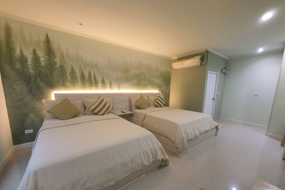 Un dormitorio con dos camas, un mural en la pared y un equipo de aire acondicionado.