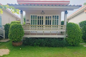 A covered porch with a bench, surrounded by well-maintained hedges and a potted plant. - Aob-oun Glamping by Zuzu (Pak Chong)