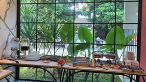 Desayuno con vistas a un jardín a través de una ventana de cuadrícula.