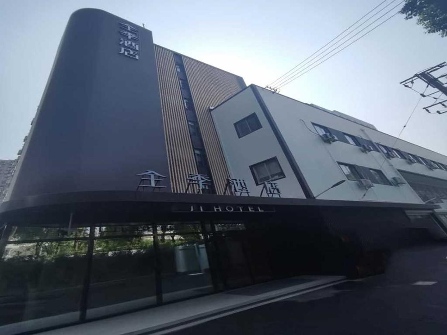 A hotel with a modern design, featuring a prominent vertical stripe and a sign indicating it is a hotel.