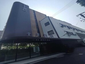 A hotel with a modern design, featuring a prominent vertical stripe and a sign indicating it is a hotel.