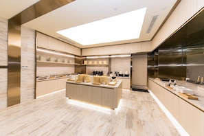 Una cocina moderna con una isla central, electrodomésticos integrados y un tragaluz.