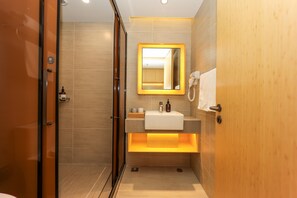 Ein modernes Badezimmer mit einem Holz-Waschtisch, einem Spiegel, einem Handtuch und einem Föhn.