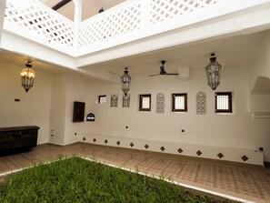 Un interior espacioso con techo alto, iluminación decorativa y suelo estampado.